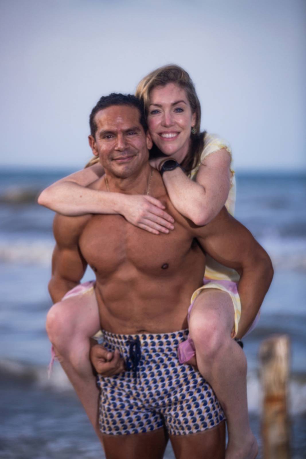 Omar giving Janine a piggyback on the beach